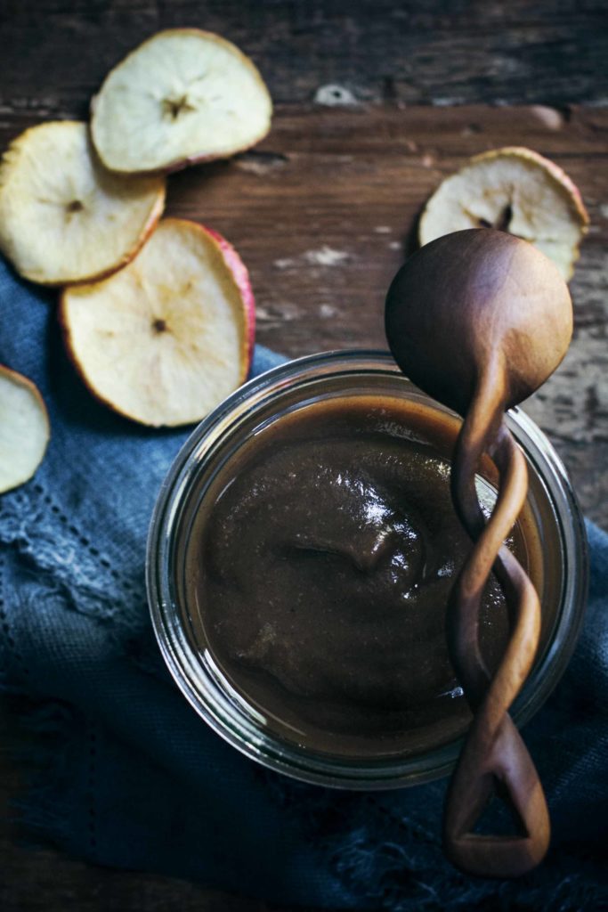 Apple butter in a jar with wooden spoon